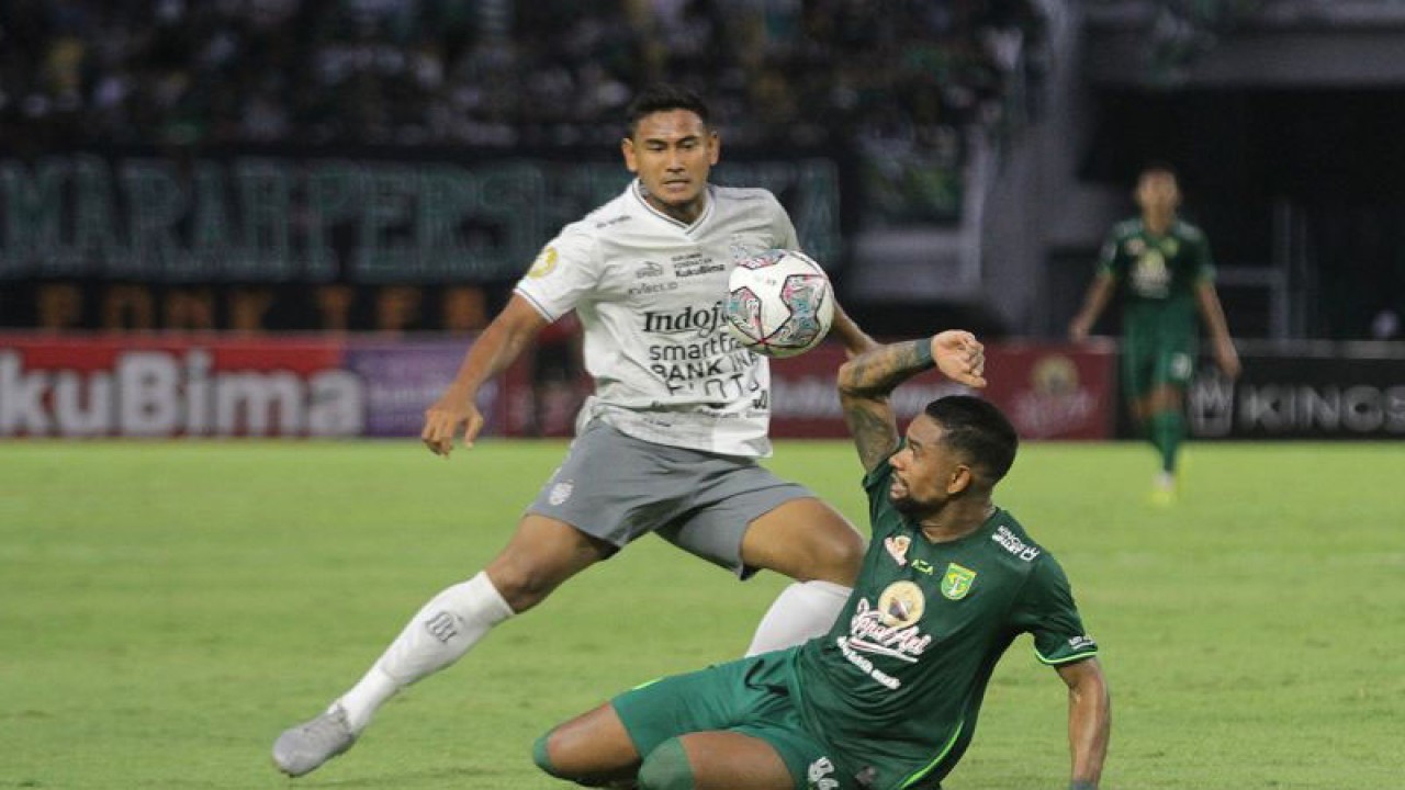 Pesepak bola Persebaya Silvio Rodrigues Pereira Junior (kanan) berebut bola dengan pesepak bola Bali United Haudi Abdillah (kanan) saat pertandingan Liga 1 di Stadion Gelora Bung Tomo, Surabaya, Jawa Timur, Jumat (2/9/2022). Persebaya kalah melawan Bali United dengan skor akhir 0-1. ANTARA FOTO/Moch Asim/aww.