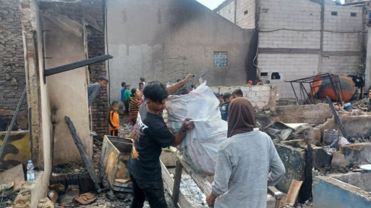 Sejumlah warga mengambil barang-barang dari rumah yang terbakar di Desa Sukamenak, Kecamatan Margahayu, Kabupaten Bandung, Provinsi Jawa Barat, Selasa (7/2/2023). (ANTARA/Bagus Ahmad Rizaldi)