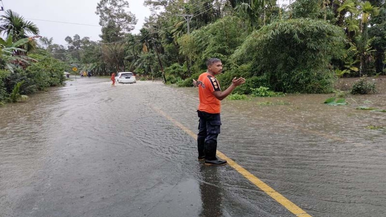 Petugas BPBD mengatur lalu lintas di ruas jalan yang terendam banjir di Kabupaten Simeulue, Aceh, Senin (13/2/2023). ANTARA/HO/BPBD Simeulue