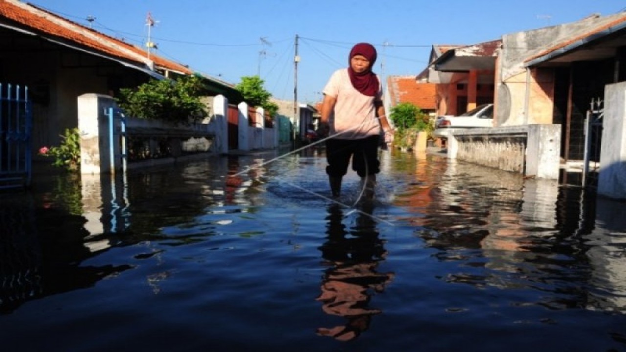 Ilustrasi - Seorang warga melintas di genangan air saat banjir rob di perumahan Martoloyo, Tegal, Jateng. FOTO ANTARA/Oky Lukmansyah/ss/mes/13