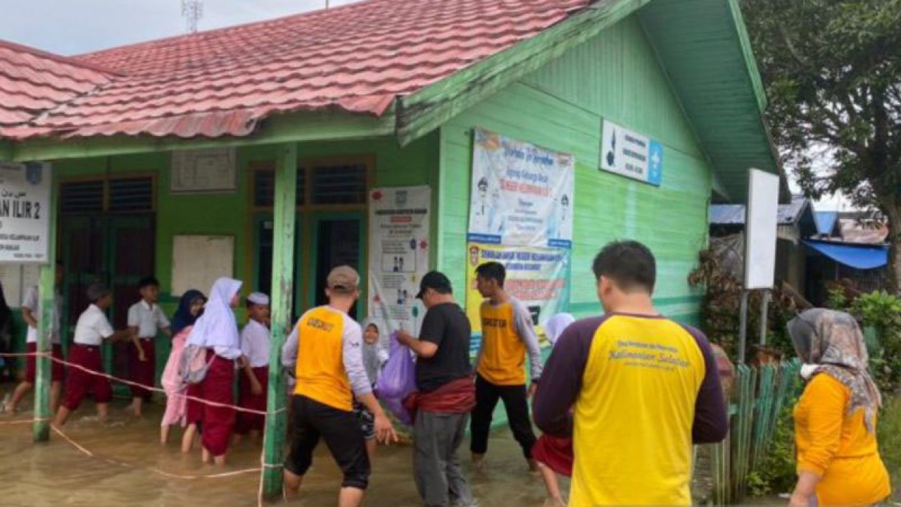 Gubernur Kalsel H Sahbirin Noor (baju hitam) saat turun langsung ke daerah banjir di Kabupaten Banjar, di salah satu sekolah untuk bagi bantuan, beberapa waktu lalu. (ANTARA/HO-Humas Pemprov Kalsel)