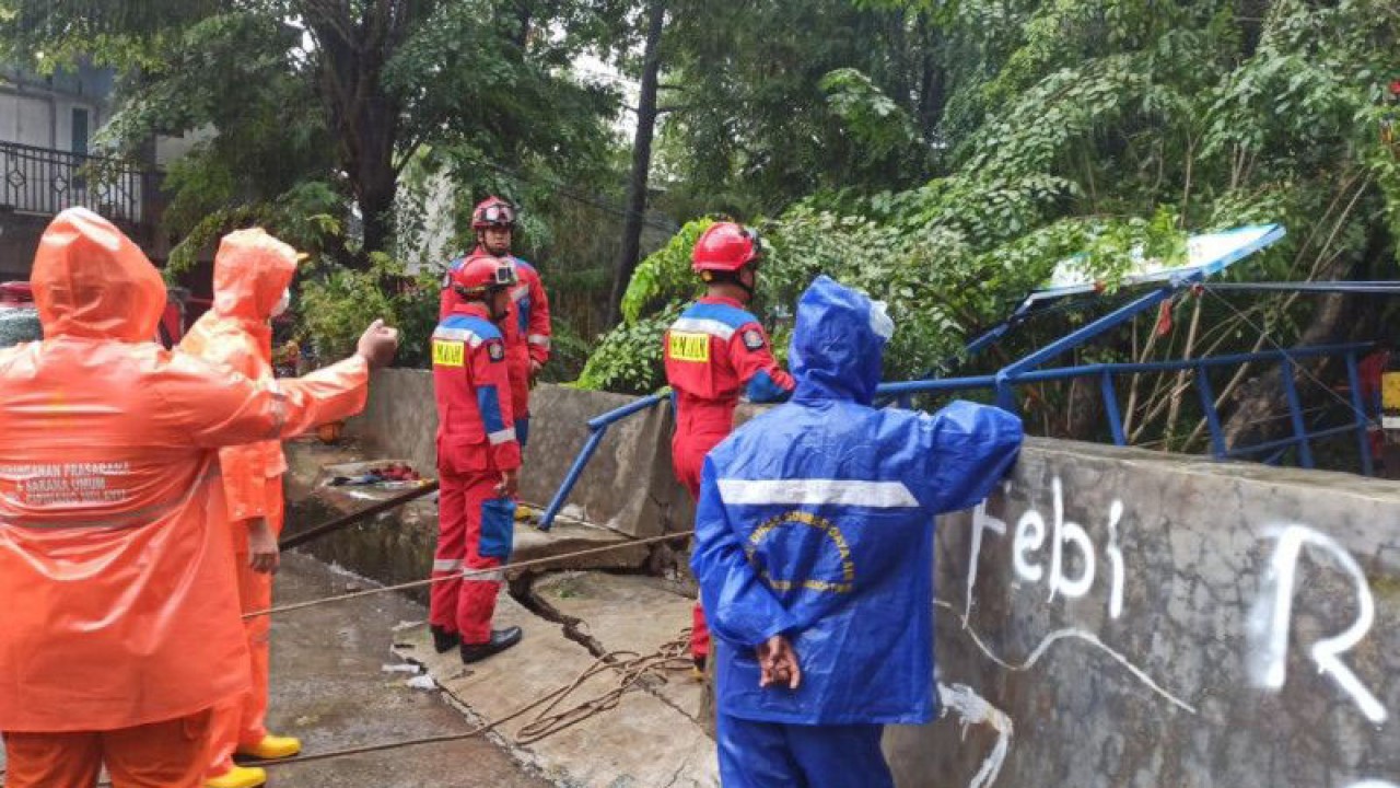 Petugas gabungan melakukan penanganan jembatan ambruk akibat tertimpa pohon tumbang karena hujan lebat dan angin kencang di Kelurahan Cipinang Melayu, Jakarta Timur, Jumat (24/2/2023). ANTARA/HO-BPBD DKI