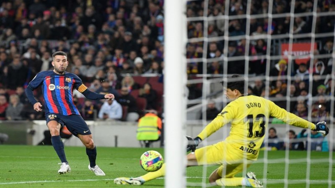 Bek Barcelona Jordi Alba (kiri) menendang bola untuk mencetak gol pada pertandingan Liga Spanyol melawan Sevilla, yang dimainkan di Stadion Camp Nou, Barcelona, Senin (6/2/2023) dini hari WIB. (ANTARA/AFP/JOSEP LAGO)
