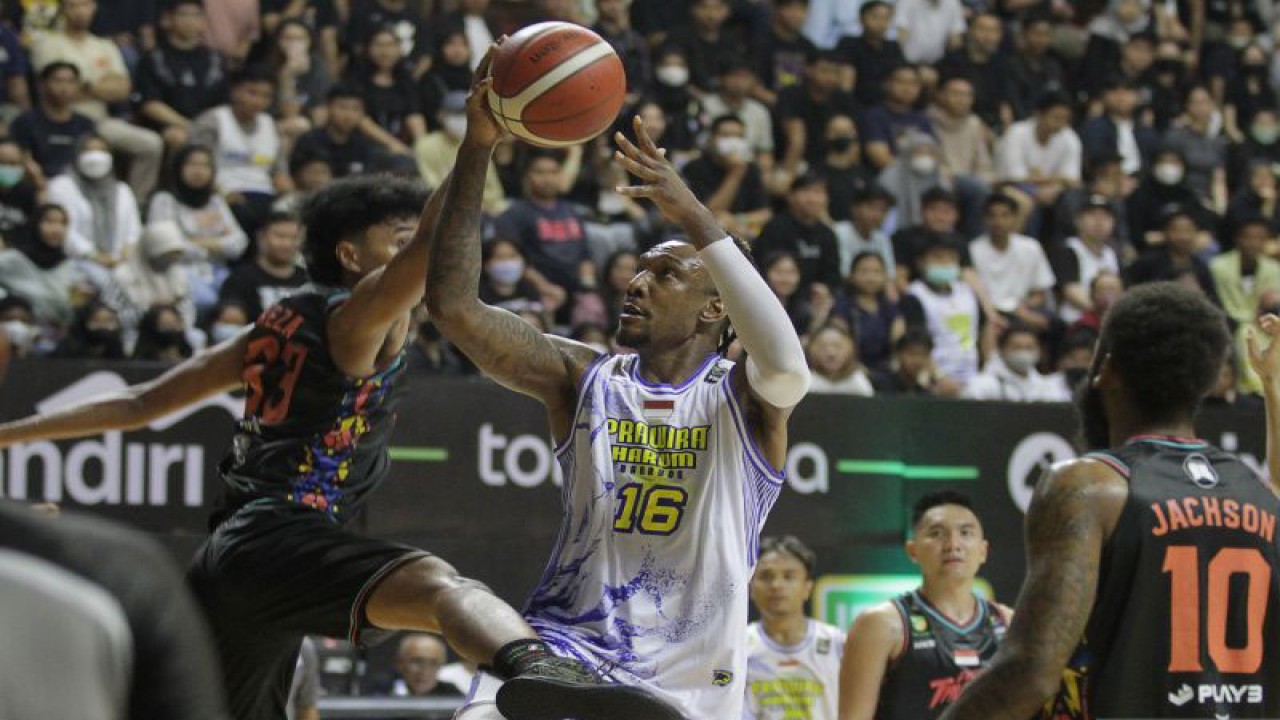 Arsip - Pebasket Prawira Harum Bandung Jarred Dwayne Shaw (tengah) berusaha memasukkan bola yang coba dihalau pebasket Evos Thunder Bogor Rheza Saputra Butarbutar (kiri) saat pertandingan Indonesian Basketball League (IBL) 2023 Seri III di DBL Arena, Surabaya, Jawa Timur, Sabtu (11/2/2023). ANTARA FOTO/Moch Asim/rwa. (ANTARA FOTO/MOCH ASIM)