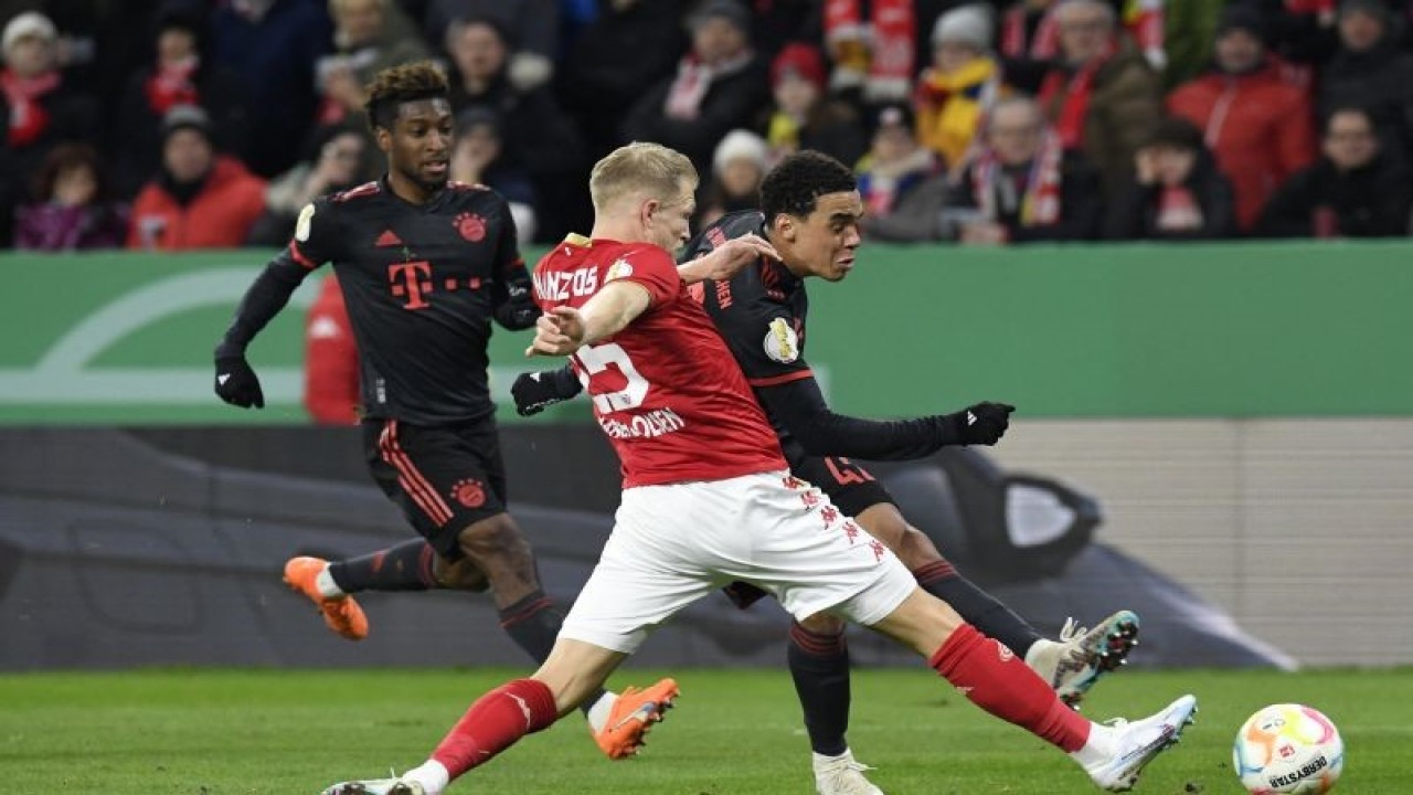 Gelandang Bayern Munich Jamal Musiala (kanan) berduel memperbutkan bola dengan bek Mainz Andreas Hanche-Olsen pada pertandingan 16 besar Piala Jerman yang dimainkan di Mewa Arena, Mainz, Kamis (2/2/2023) dini hari WIB. (ANTARA/AFP/THOMAS KIENZLE)