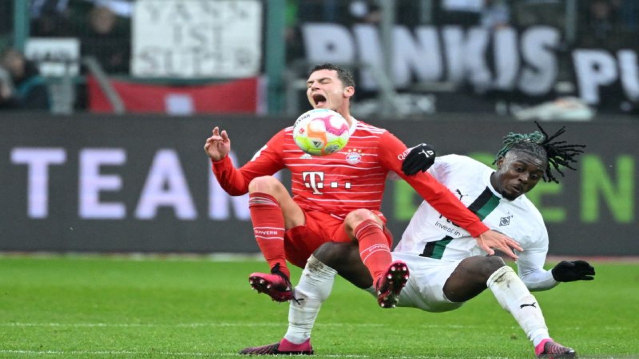 Bek Bayern Munich Benjamin Pavard (kiri) dan gelandang Moenchengladbach Kouadio Konevie berduel memperebutkan bola pada pertandingan Liga Jerman yang dimainkan di Borussia Park, Moenchengladbach, Sabtu (18/2/2023) malam WIB. (ANTARA/AFP/INA FASSBENDER)