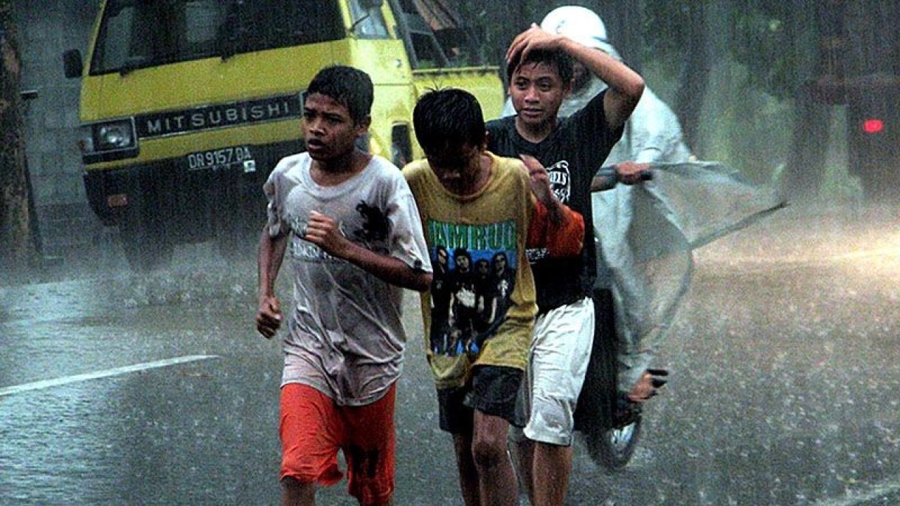 Ilustrasi: Sejumlah warga mandi hujan di Jalan Raya Lembar, Lombok Barat, NTB, Kamis (7/1). FOTO ANTARA/Budi Afandi/Koz/pd/pri.