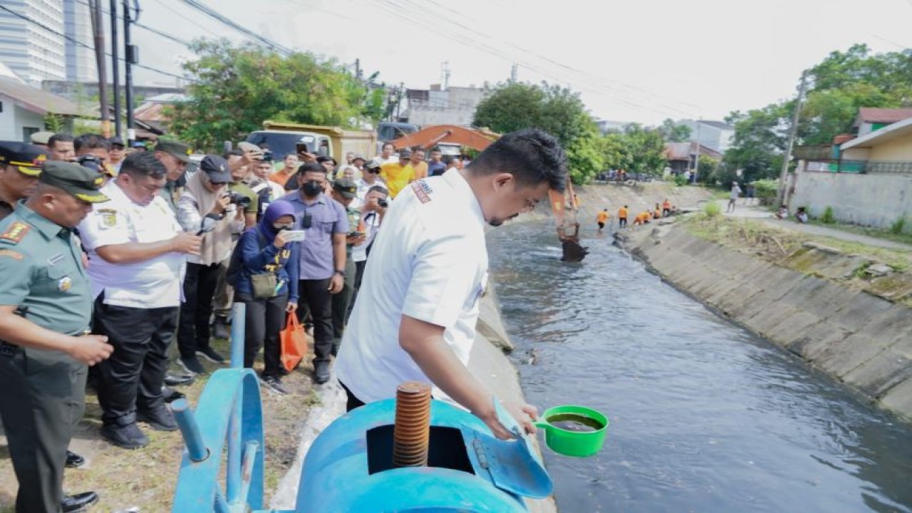 Wali Kota Medan Bobby Nasution berdiri memengang gayung di pinggir Sungai Putih, Medan, Sumut, Rabu (22/2/2023). (ANTARA/HO-Diskominfo Kota Medan)