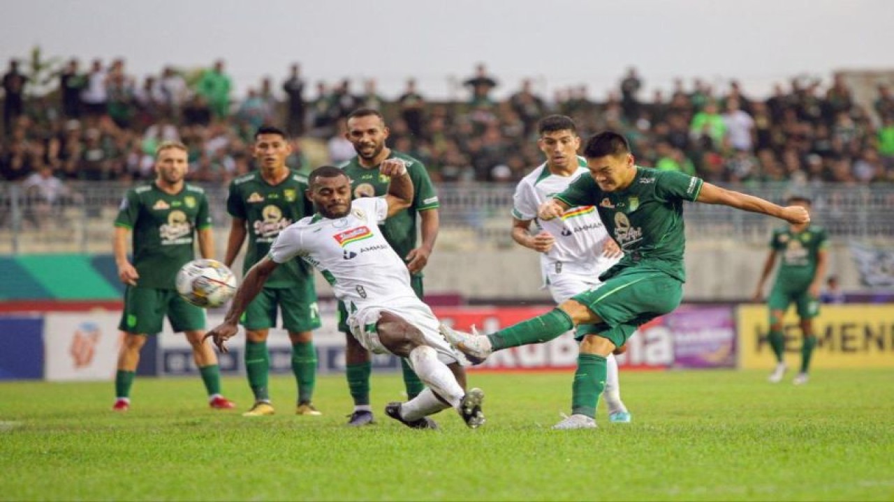 Pemain Persebaya Sho Yamamoto (kanan) dihadang oleh pemain PSS Sleman Marckho Merauke (kiri) saat menendang bola dalam laga lanjutan Liga 1 Indonesia musim. 2022/2023 di Stadion Gelora Joko Samudro Gresik, Senin (13/2/2023). (ANTARA/Rizal Hanafi)