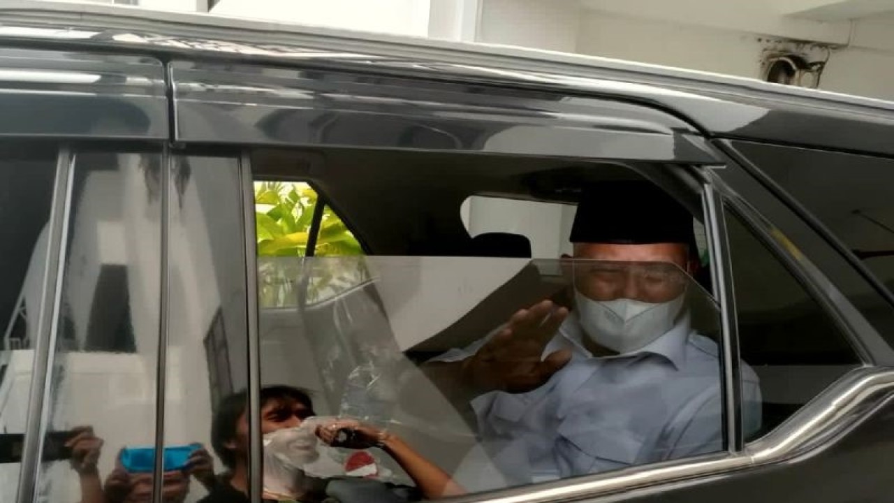 Bupati Lombok Timur M. Sukiman Azmy melambaikan tangan kepada wartawan dari dalam kendaraan usai menjalani pemeriksaan sebagai saksi kasus dugaan korupsi dalam kegiatan tambang pasir besi di Blok Dedalpak dengan luas lahan 1.348 hektare di Kantor Kejati NTB, Senin (13/2/2023). (ANTARA/Dhimas B.P.)