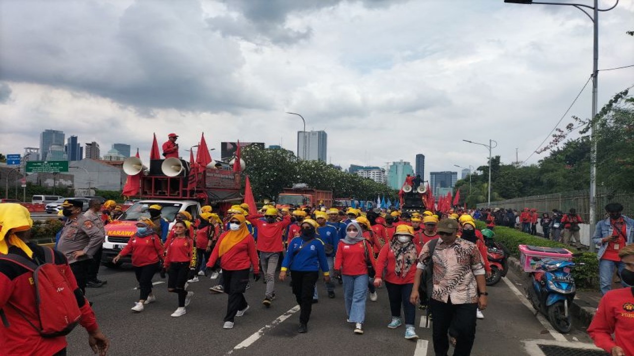 Massa buruh berjalan kaki menuju depan Gedung DPR RI, Senayan, Jakarta Pusat, Selasa (28/2/2023). ANTARA/Walda