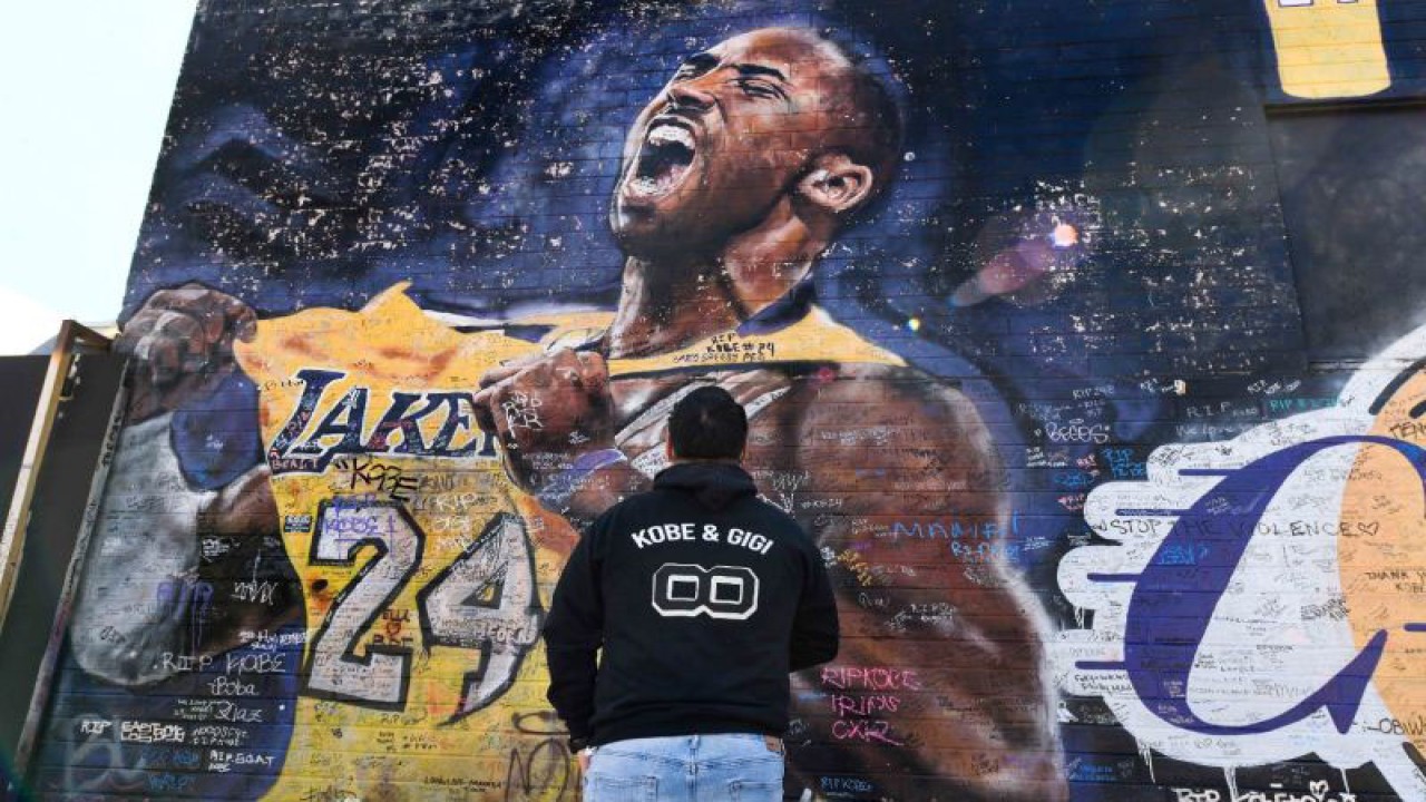 Carlos Mendoza memotret mural Kobe Bryant di sebuah gang dekat Staples Center, pusat kota Los Angeles, California, Amerika Serikat, Selasa (26/1/2021). Bryant dan putrinya Gianna serta tujuh orang lainnya tewas pada kecelakaan helikopter pada 26 Januari 2020. ANTARA FOTO/Robert Hanashiro-USA TODAY Sports/HP/djo