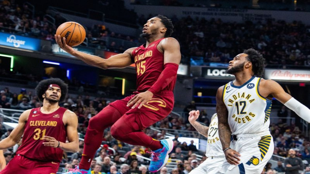 Guard Cleveland Cavaliers Donovan Mitchell (tengah) berupaya memasukkan bola melewati forward Indiana Pacers forward Oshae Brissett (kanan) saat kedua tim berlaga di Gainbridge Fieldhouse. Indianapolis, Indiana, Minggu (5/2/2022) (USA TODAY Sports/Trevor Ruszkowski)