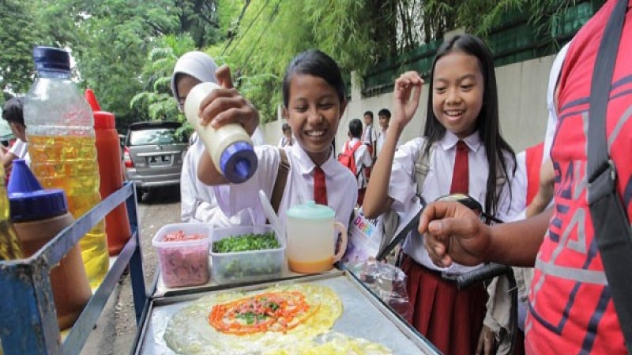 Siswi SD membeli jajanan di Jakarta, Selasa (11/4/2017). Menjelang "Hari Bawa Bekal Nasional" yang jatuh pada tanggal 12 April, anak-anak perlu dibiasakan untuk membawa bekal makanan sehat dari rumah sehingga tidak jajan makanan yang dinilai kurang sehat. (ANTARA FOTO/Muhammad Adimaja)