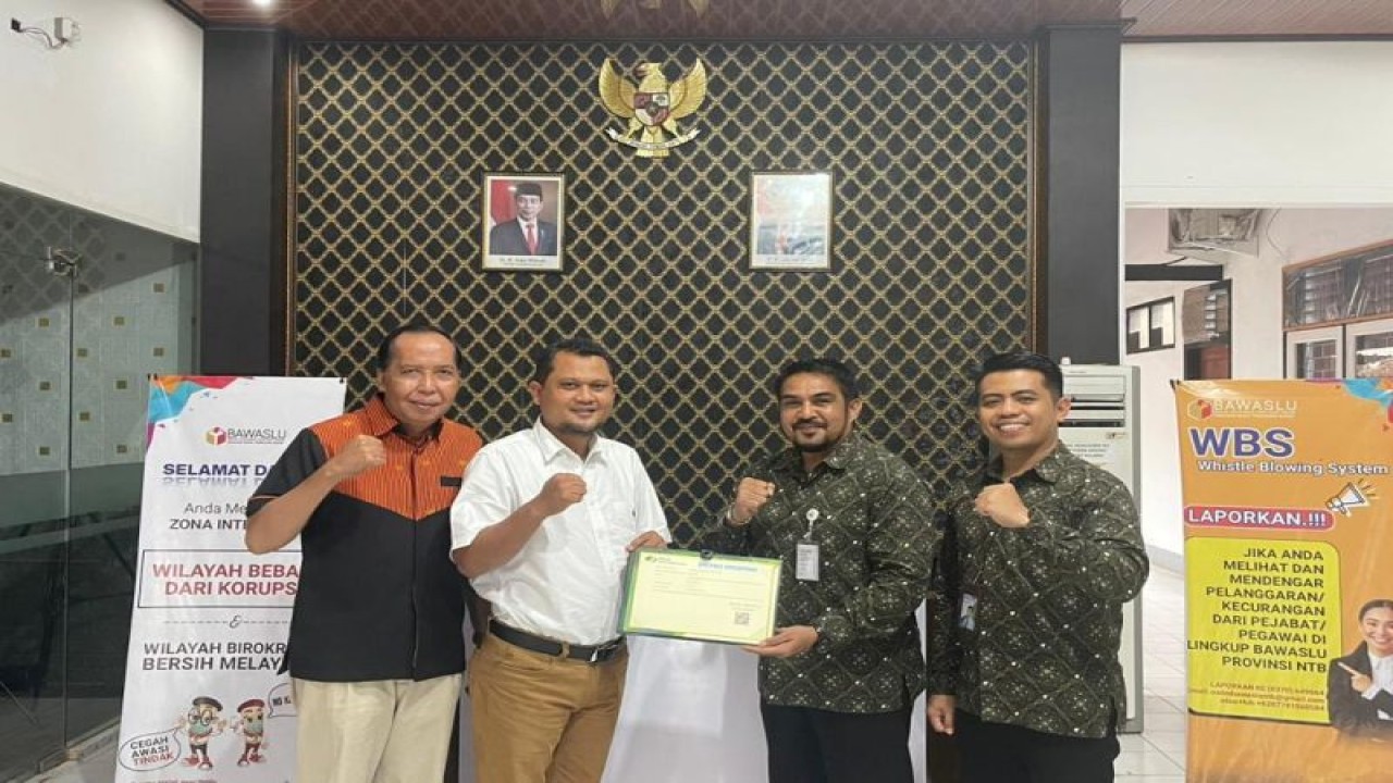 Ketua Bawaslu Provinsi NTB Itratip (kiri dua), menerima secara simbolis kartu kepesertaan program jaminan sosial ketenagakerjaan dari Kepala BPJAMSOSTEK NTB Adventus Edison Souhuwat (kanan dua) di Mataram, Jumat (3/2/2023). ANTARA/Awaludin