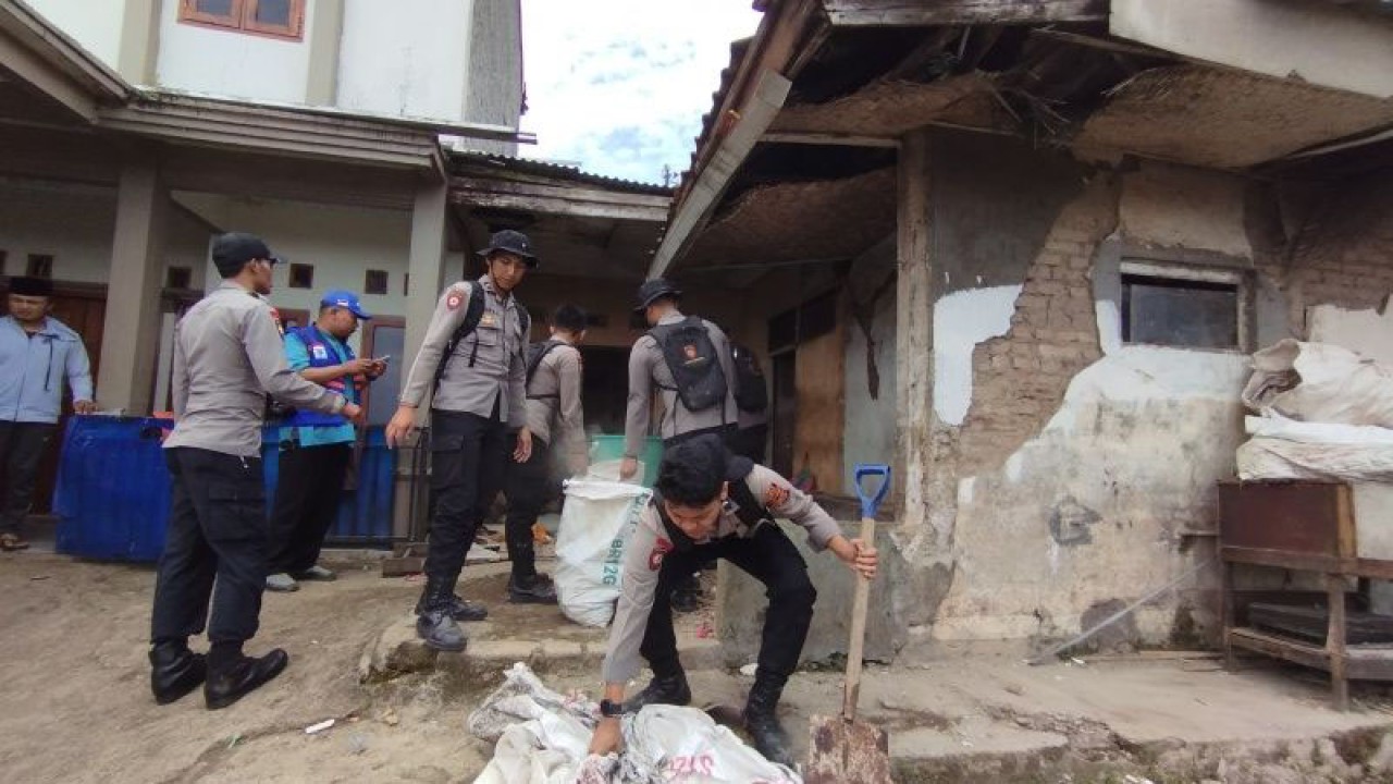 Sejumlah personel kepolisian membersihkan material rumah warga yang rusak akibat diguncang gempa bumi di Desa Barusari, Kecamatan Pasirwangi, Kabupaten Garut, Jawa Barat, Kamis (2/2/2023). (ANTARA/Feri Purnama)