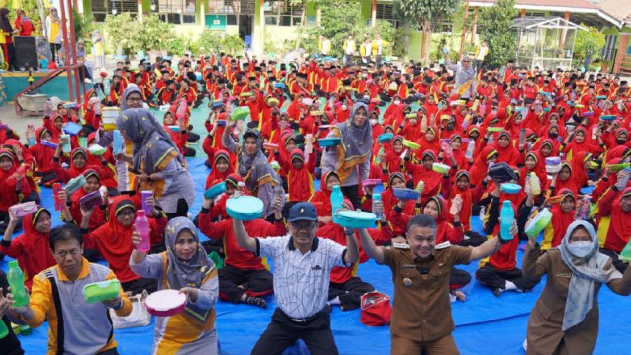 Wali Kota Palu Hadianto Rasyid (kedua dari kanan) memasang botol air minum dan tempat makanan pada peluncuran "Gerakan Aksi Bergizi dan Penanganan Sampahku Tanggungjawabku" di MTs Negeri 2 Palu, Selasa (7/2/2023). ANTARA/HO-Humas Pemkot Palu
