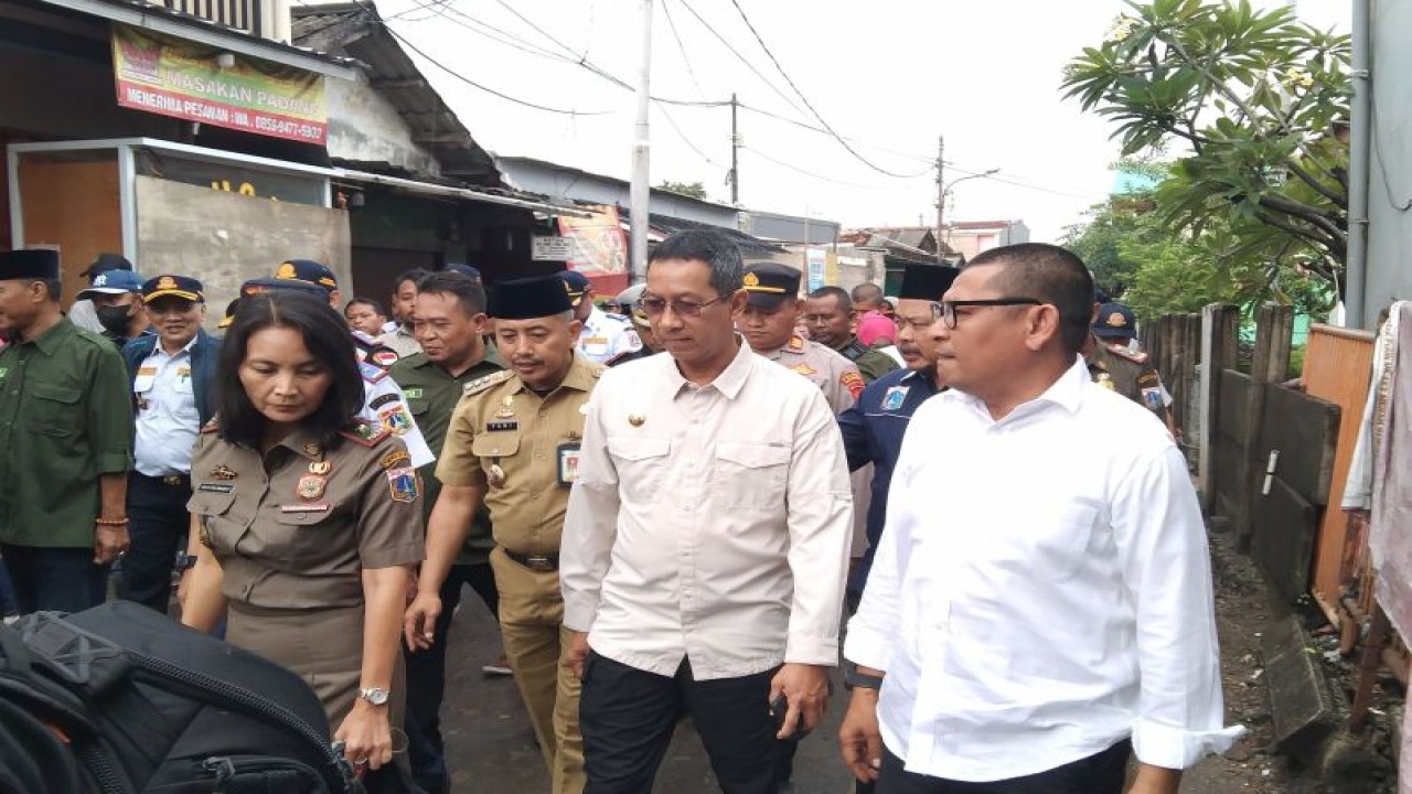 Penjabat Gubernur DKI Heru Budi Hartono (dua dari kanan) saat meninjau kemacetan dan genangan di Kelurahan Semanan, Kalideres, Jakarta Barat (27/2/2023) ANTARA/Dewa Ketut Sudiarta Wiguna