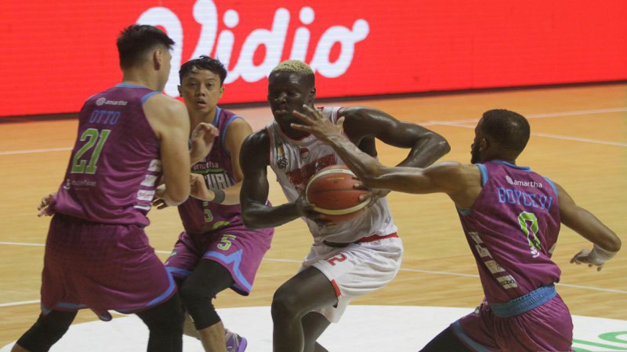 Pebasket Indonesia Patriots Dame Diagne (kedua kanan) berusaha melewati pebasket RJ Amartha Hangtuah Jakarta Ronnie Lee Boyce III (kanan), Tifan Eka Pradita (kedua kiri), dan Yosua Otto Sunarko Judaprajitna (kiri) dalam pertandingan Indonesian Basketball League (IBL) 2023 di DBL Arena, Surabaya, Jawa Timur, Sabtu (18/2/2023). Indonesia Patriots mengalahkan RJ Amartha Hangtuah Jakarta dengan 66-63. ANTARA FOTO/Moch Asim/tom. (ANTARA FOTO/MOCH ASIM)