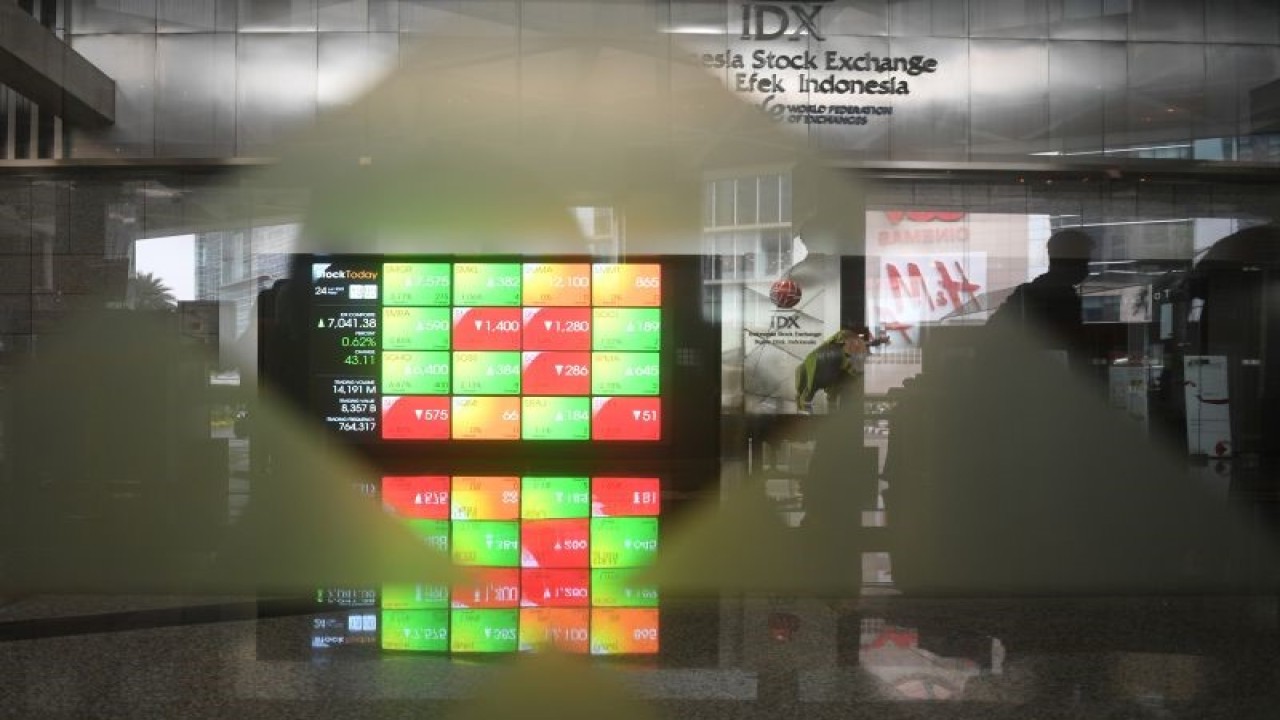 Seorang pria melintasi layar digital pergerakan saham di Bursa Efek Indonesia, Jakarta, Jumat (24/6/2022). ANTARA FOTO/Akbar Nugroho Gumay/foc.