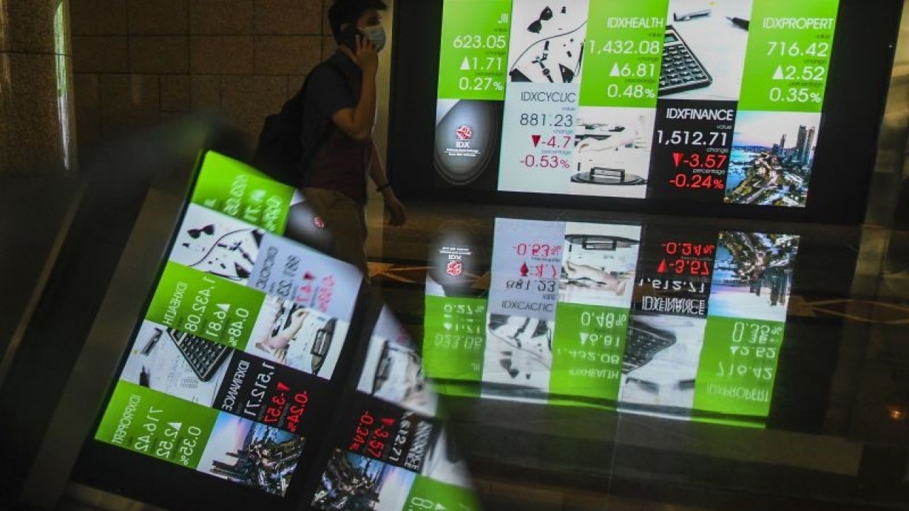 Karyawan melintas di samping layar elektronik yang menunjukkan pergerakan Indeks Harga Saham Gabungan (IHSG) di Bursa Efek Indonesia, Jakarta, Jumat (9/9/2022). . ANTARA FOTO/Galih Pradipta/aww.