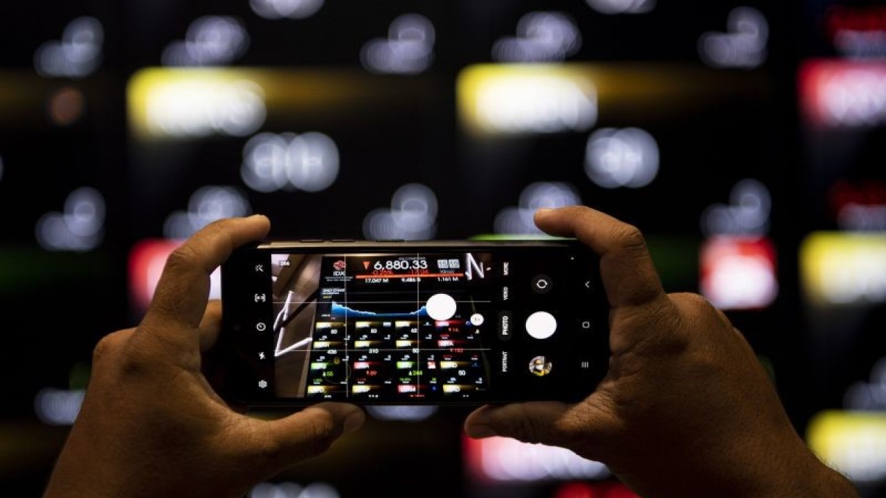 Karyawan memotret layar Indeks Harga Saham Gabungan (IHSG) di Bursa Efek Indonesia, Jakarta, Jumat (10/2/2023). Perdagangan IHSG di akhir pekan ini ditutup melemah 17,04 poin atau 0,25 persen ke posisi 6.880,3. ANTARA FOTO/Sigid Kurniawan/YU