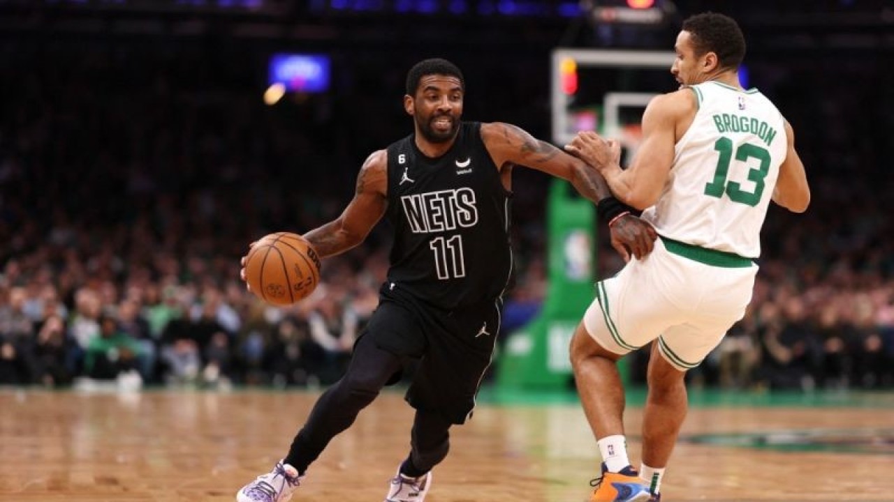 Kyrie Irving dari Brooklyn Nets menggiring bola melewati Malcolm Brogdon dari Boston Celtics selama paruh pertama di TD Garden pada 01 Februari 2023 di Boston, Massachusetts. (ANTARA/Getty Images via AFP/MADDIE MEYER)
