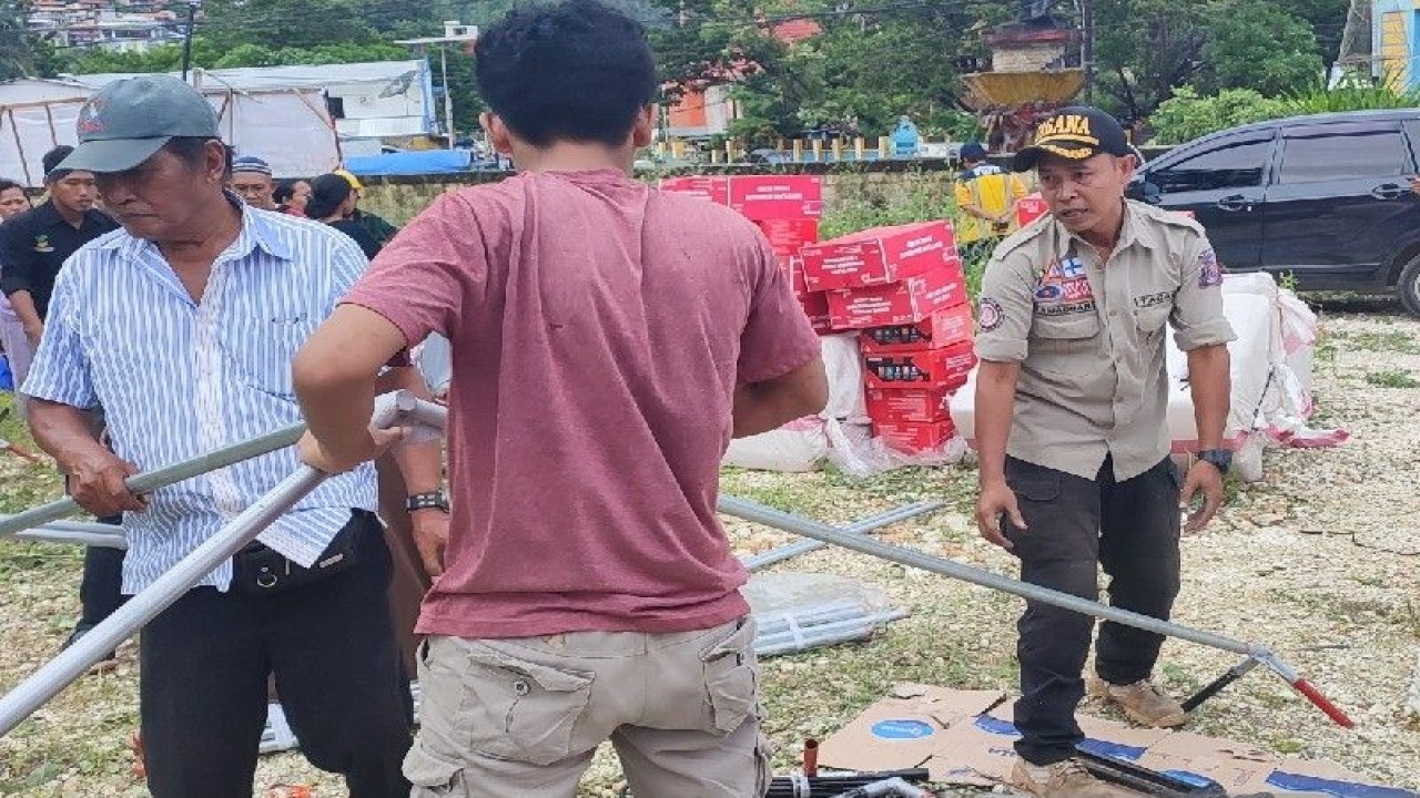 Petugas Tagana dari Kemensos bersama warga membangun tenda bagi pengungsi warga Kota Jayapura karena khawatir gempa susulan. (ANTARA/Evarukdijati)