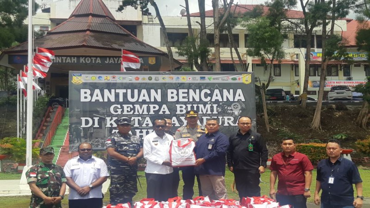 Pranata Keuangan APBN Penyelia, Biro Administrasi, Deputi Bidang Administrasi dan Pengelolaan Istana, Sekretariat Presiden, Tatang (kanan) saat menyerahkan bantuan bahan pokok kepada Penjabat Wali Kota Jayapura Frans Pekey di posko induk tanggap darurat bencana, Kota Jayapura, Rabu (15/2/2023). (ANTARA/Ardiles Leloltery)