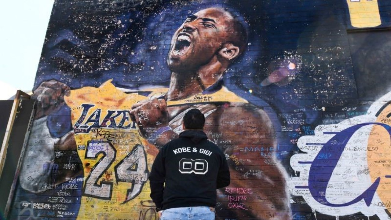 Carlos Mendoza memotret mural Kobe Bryant di sebuah gang dekat Staples Center, pusat kota Los Angeles, California, Amerika Serikat, Selasa (26/1/2021). Bryant dan putrinya Gianna serta tujuh orang lainnya tewas pada kecelakaan helikopter pada 26 Januari 2020. ANTARA FOTO/Robert Hanashiro-USA TODAY Sports/HP/djo