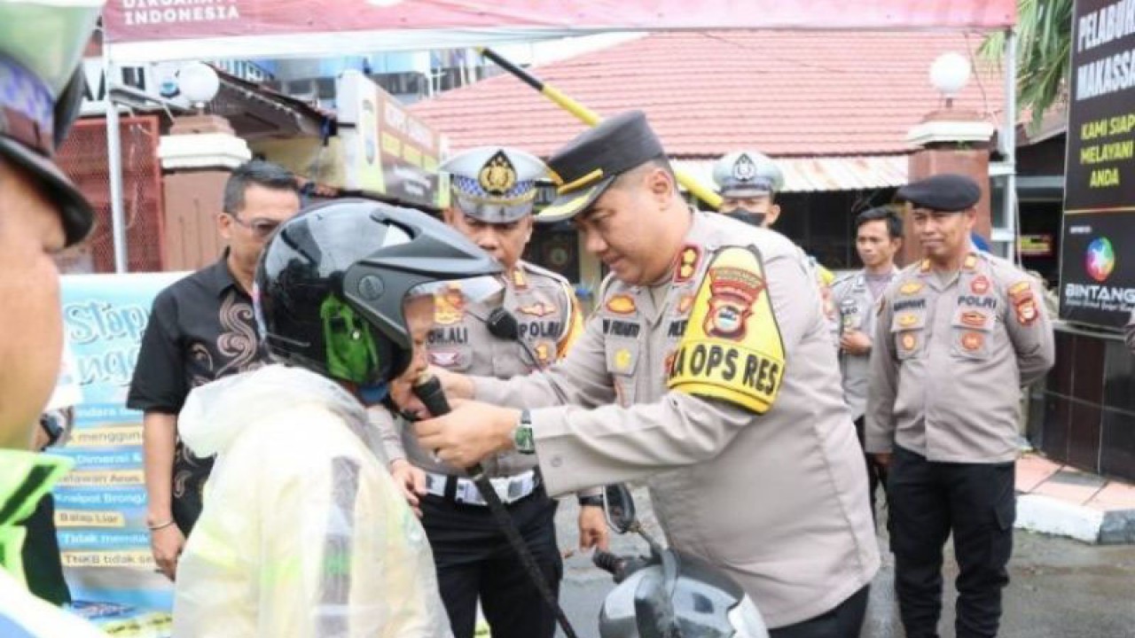 Kapolres Pelabuhan AKBP Yudi Frianto saat memasangkan helm dengan benar kepada pengendara roda dua sambil mengedukasi agar tertib berlalulintas. ANTARA/HO/Polres Pelabuhan.