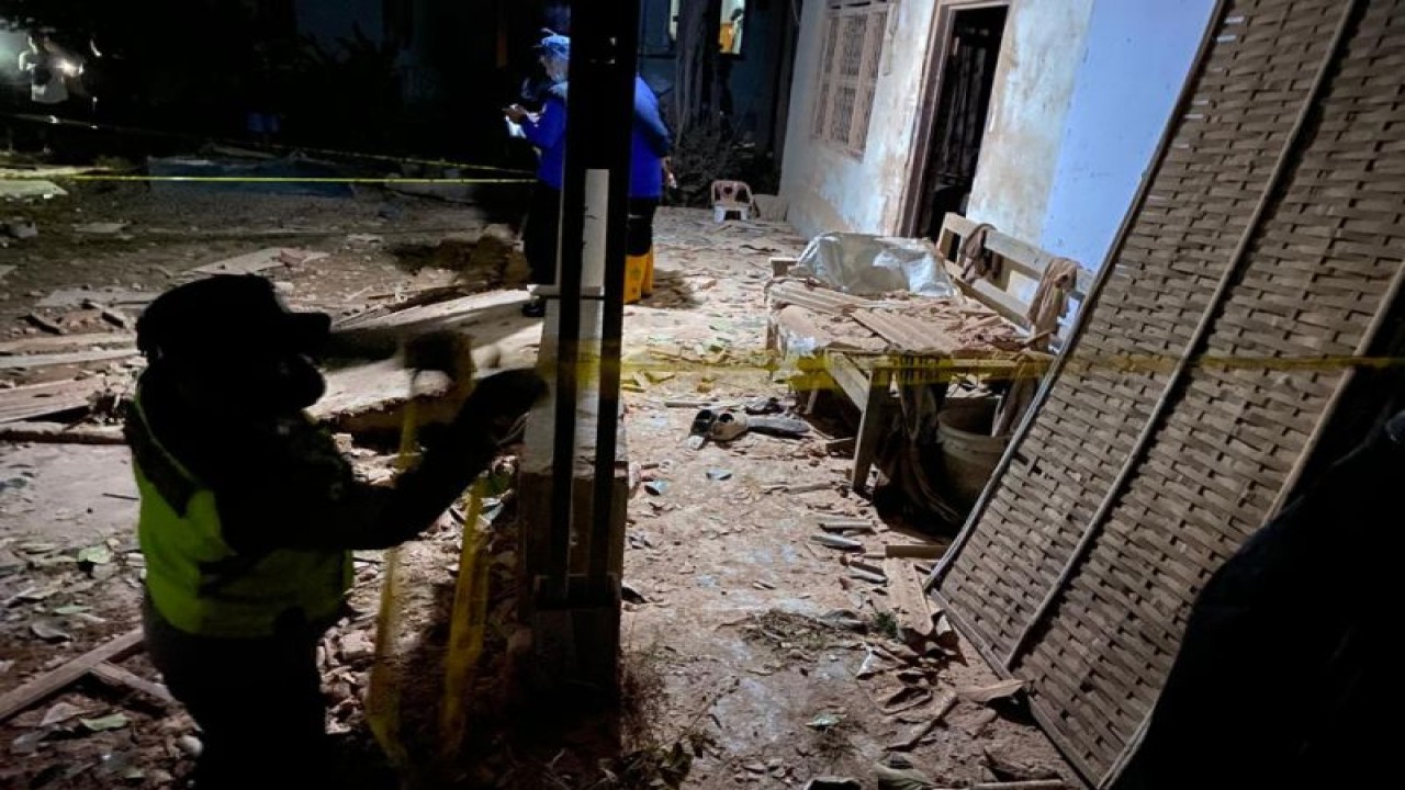 Petugas memasang garis polisi di lokasi ledakan, Dusun Tegalrejo, Desa Karangbendo, Kecamatan Ponggok, Kabupaten Blitar, Jawa Timur, Minggu (19/2/2023) malam. Satu orang meninggal dunia dan tiga lainnya masih dicari setelah insiden ledakan yang menghancurkan satu rumah. ANTARA/ HO-Polres Blitar