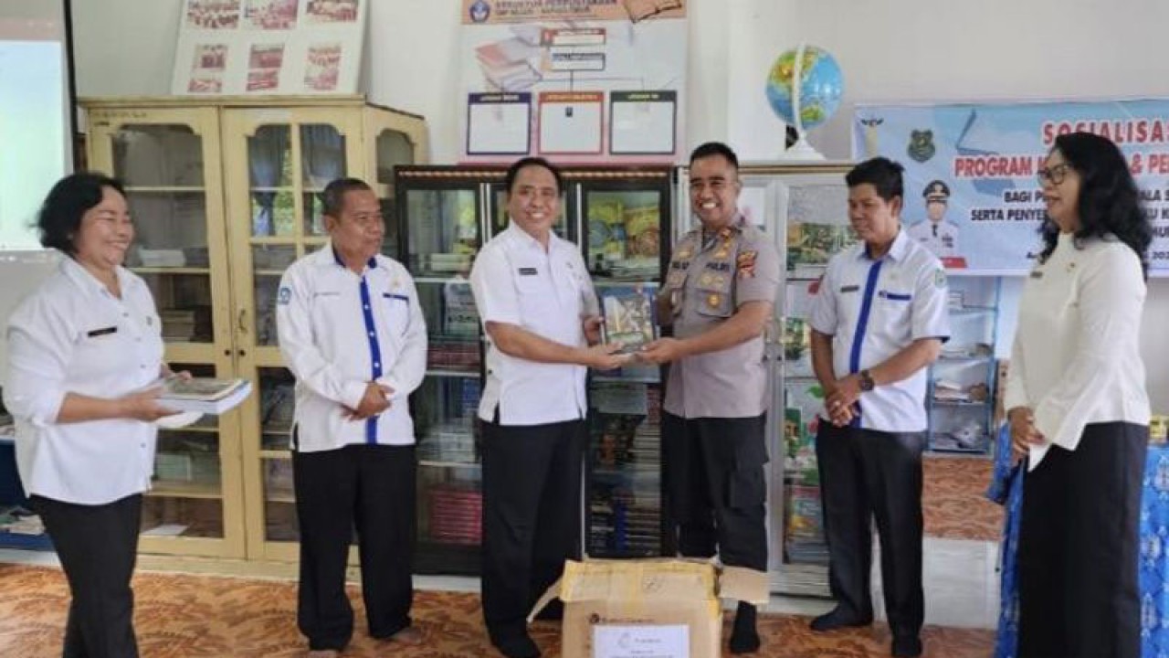 Kepala Dinas Kearsipan dan Perpustakaan Kapuas Suwarno Muriyat menyerahkan secara simbolis buku bacaan kepada Kapolsek Kapuas Timur Iptu Eko Sutrisno di Kuala Kapuas, Rabu (15/2/2023). (ANTARA/All Ikhwan)