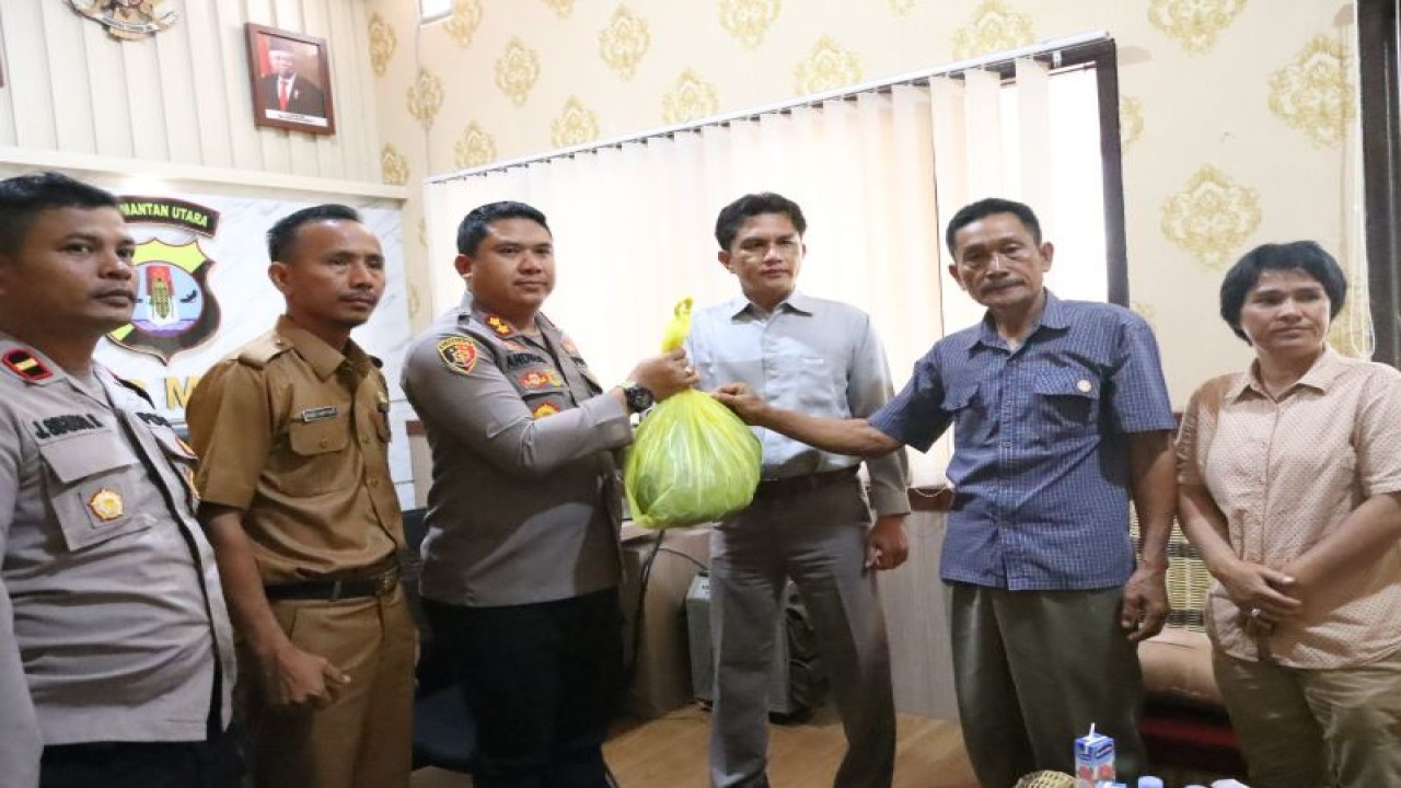 Kapolres Malinau AKBP Andreas Deddy Wijaya saat menerima barang bukti berupa baju milik LH yang korban penembakan anggota polisi Brigpol W di Mapolres Malinau pada, Senin malam (6/2). ANTARA/HO-Humas Polres Malinau.