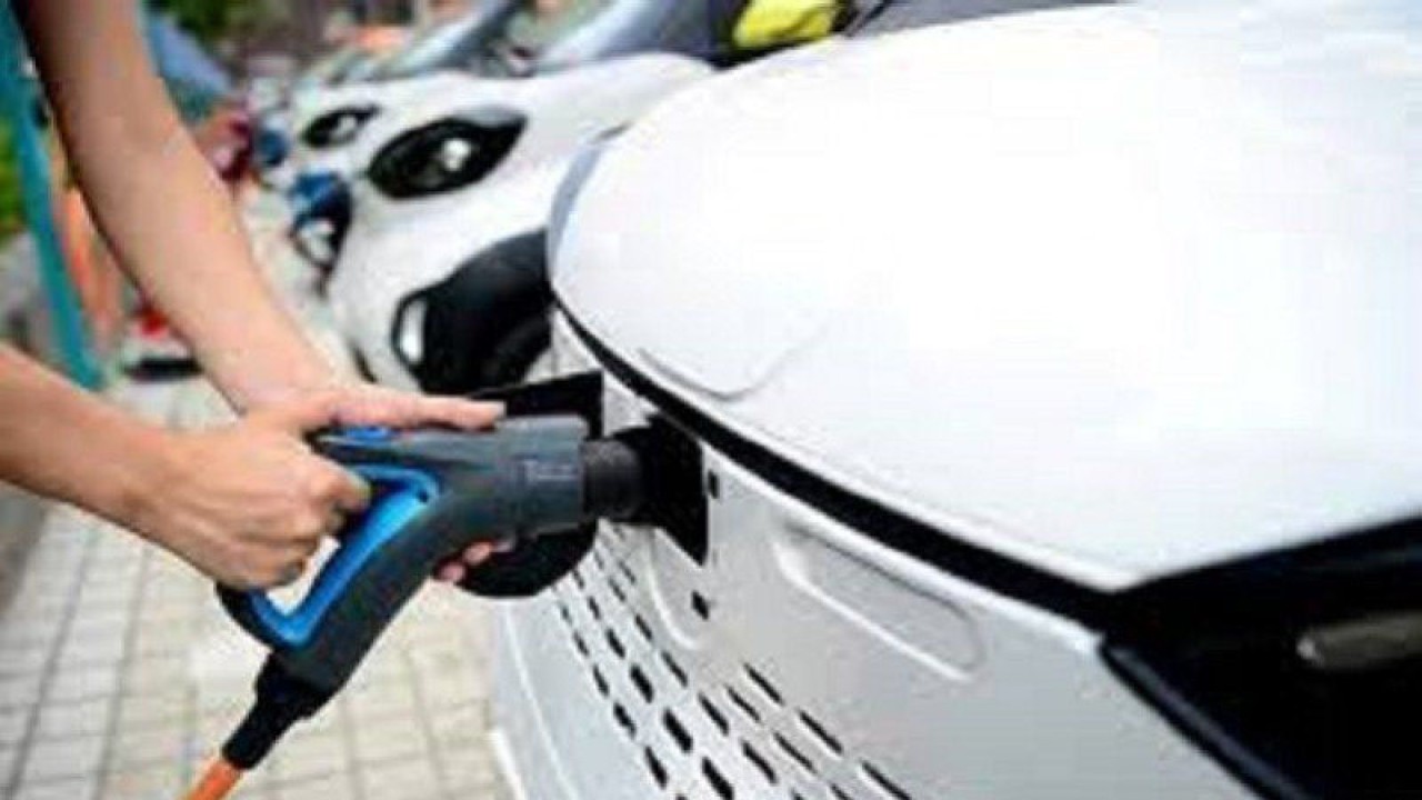 Ilustrasi - Seorang petugas menghubungkan kabel pengisi daya ke kendaraan listrik (EV) di stasiun pengisian daya. (ANTARA/REUTERS/Stringer/am)