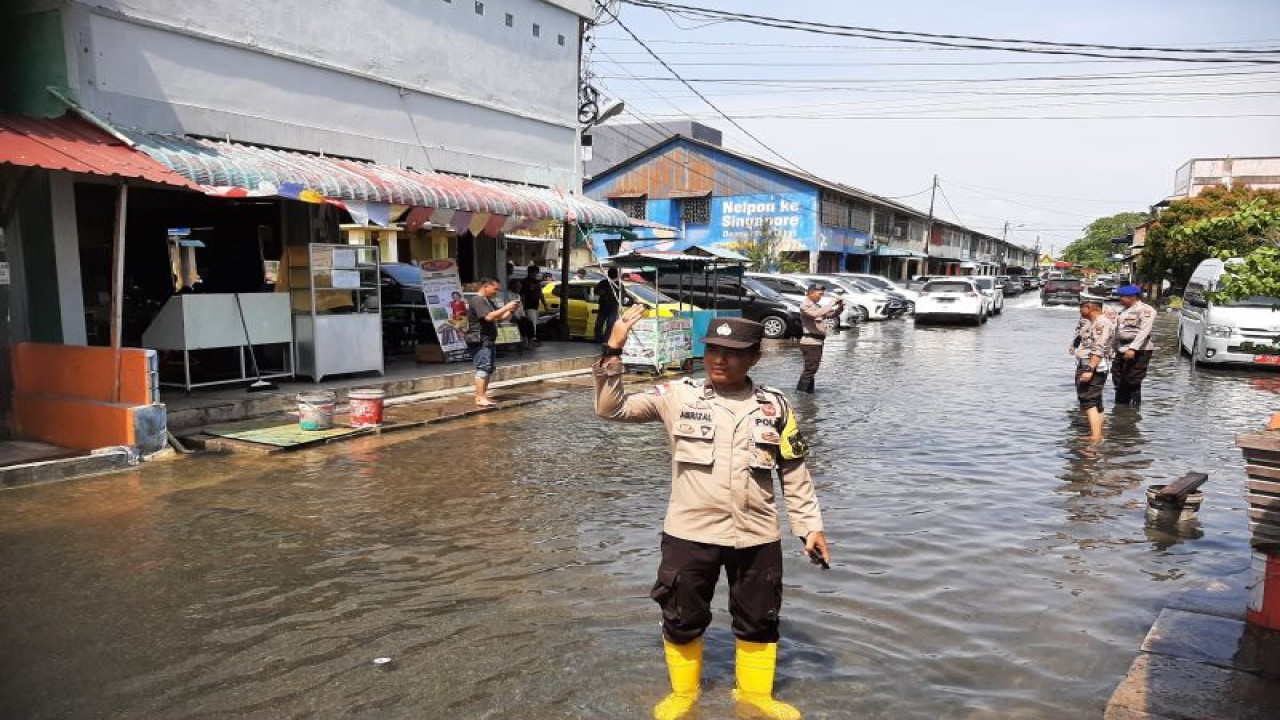 Polisi menutup akses jalan di Tanjung Uban, Kabupaten Bintan, Kepri, dampak rob, Rabu (22/2/2023). (ANTARA/Ogen)