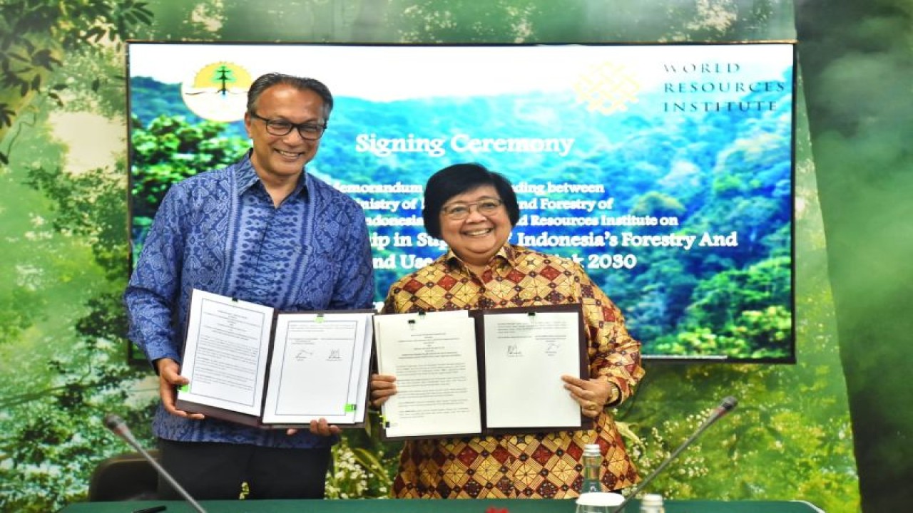 Menteri Lingkungan Hidup dan Kehutanan Siti Nurbaya Bakar (kanan) bersama CEO World Resources Institute Ani Dasgupta (kiri) memperlihatkan nota kesepahaman terkait kerja sama teknis untuk mendukung target Indonesia's FOLU Net Sink 2030 di Gedung Manggala Wanabakti, Jakarta, Jumat (17/2/2023). (ANTARA/HO-Kementerian LHK)