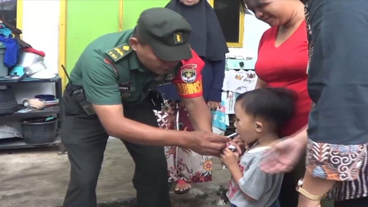 Babinsa Kelurahan Sungai Bambu Sersan Mayor Harun Susanto memberikan susu kepada anak bawah lima tahun (balita) di Kelurahan Sungai Bambu, Tanjung Priok, Jakarta Utara, Kamis (23/2/2023). ANTARA/HO-Jurnalis Jakarta Utara