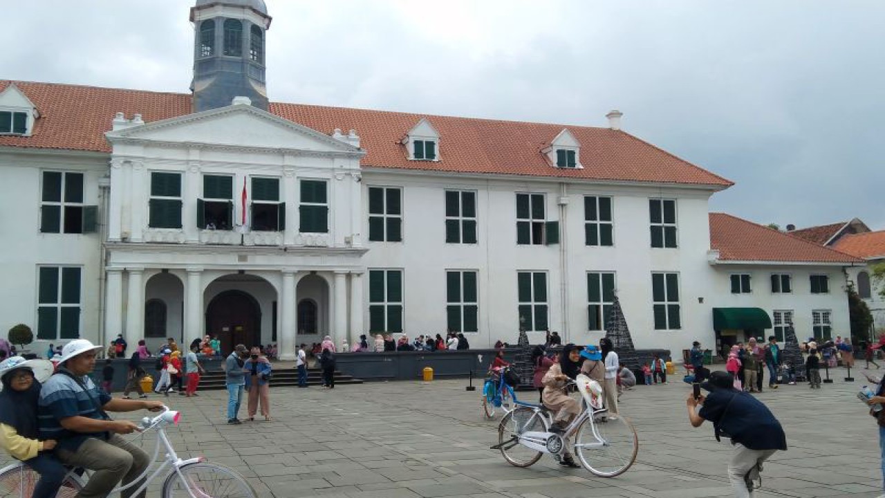 Wisatawan berfoto dengan latar belakang Museum Fatahillah di kawasan Kota Tua, Jakarta Barat, Sabtu (24/12/2022). ANTARA/Dewa Ketut Sudiarta Wiguna