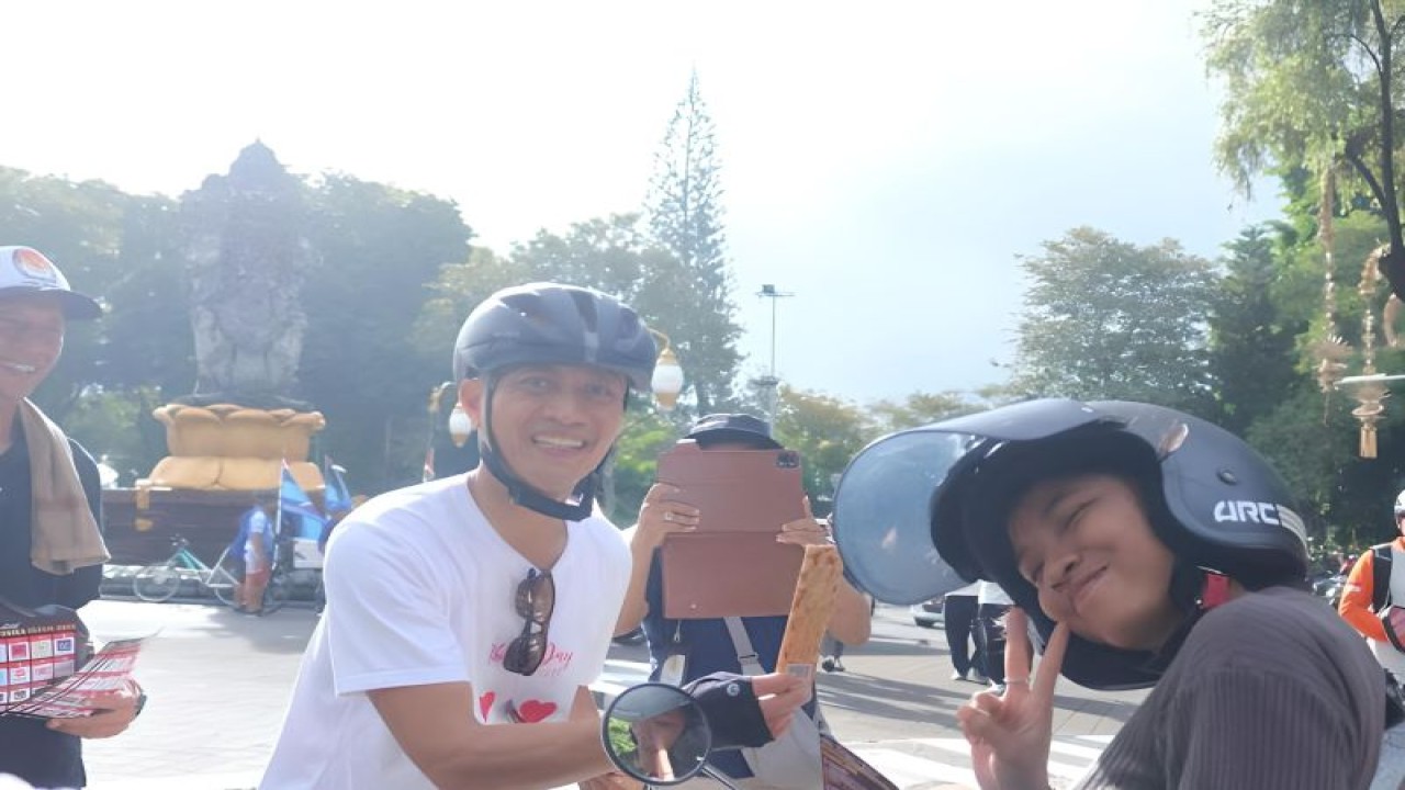 Ketua KPU Denpasar I Wayan Arsa Jaya saat membagikan coklat dalam rangka setahun jelang Pemilu 2024 di Denpasar, Selasa (14/2/2023). ANTARA/HO-KPU Denpasar.