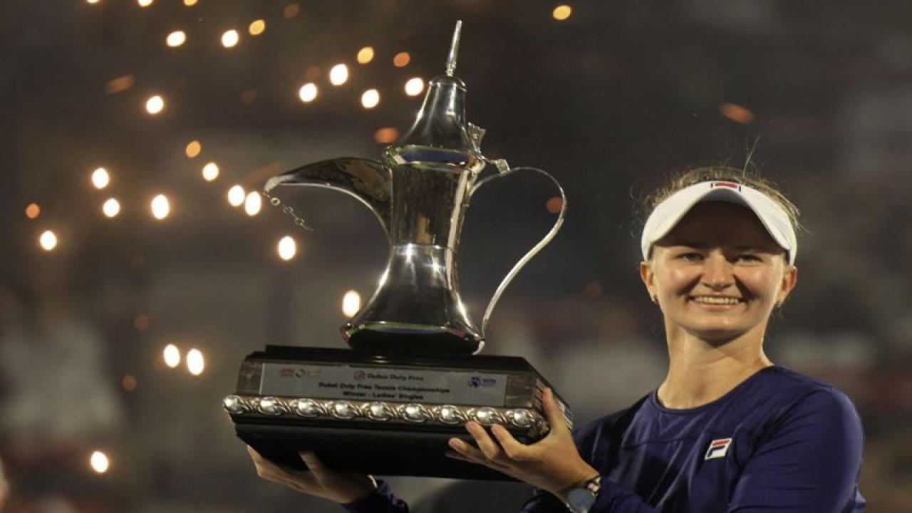 Petenis Ceko Barbora Krejcikova mengangkat trofi Kejuaraan Tenis WTA Dubai Duty Free setelah mengalahkan Iga Swiatek asal Polandia di final di Dubai. (25/2/2023) (AFP/KARIM SAHIB)