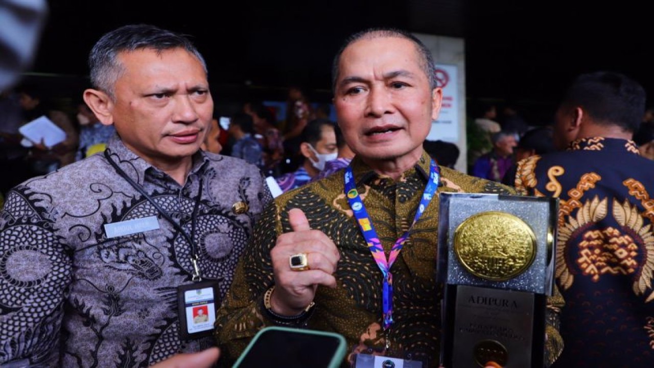 Bupati Kudus Hartopo memegang piala Adipura 2022 didampingi Kepala Dinas Perumahan Kawasan Pemukiman dan Lingkungan Hidup (PKPLH) Kabupaten Kudus Abdul Halil di Jakarta, Selasa (28/2/2023). (ANTARA/HO-Humas Pemkab Kudus)