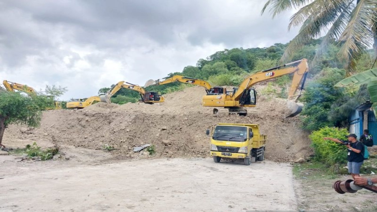 Sejumlah alat berat serta truk dioperasikan untuk membersihkan material tanah longsro yang menimbun ruas Jalan Trans Timor di Desa Noelmina, Kecamatan Takari, Kabupaten Kupang, NTT, Minggu (19/2/2023). (FOTO ANTARA/Aloysius Lewokeda)