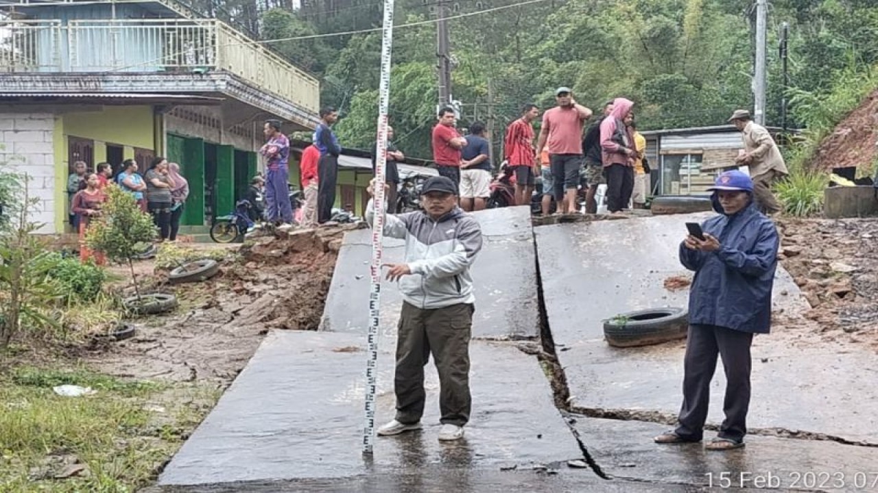 Warga melihat kondisi jalan yang rusak parah akibat ambles terseret longsor di Mryan, Ponorogo, Kamis (16/2/2023) (ANTARA/HO - SDP)