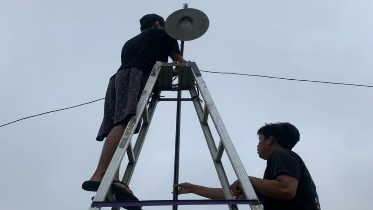 Dua orang mahasiswa tengah memperbaiki penerangan jalan di Desa Kebon Sari, Delanggu, Klaten, Jawa Tengah, Minggu (19/2/2023). ANTARA/HO-Humas UNS.