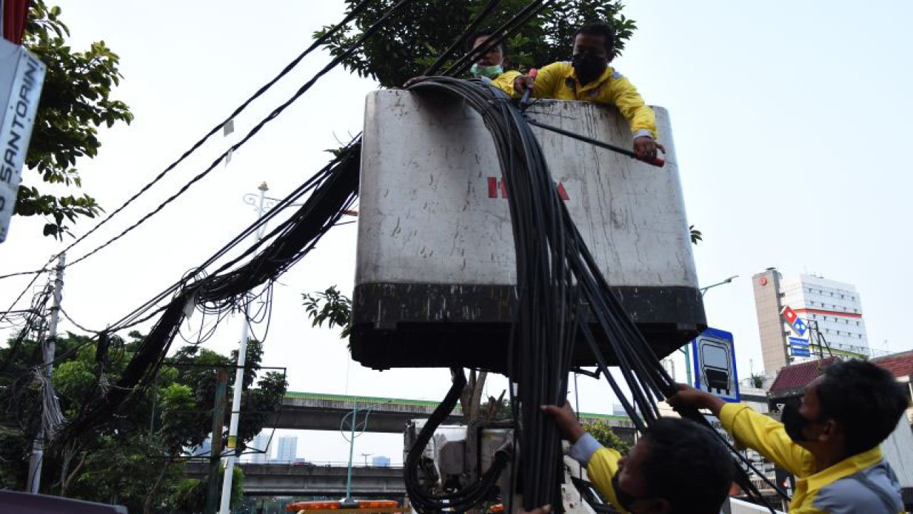 Arsip Foto - Petugas Bina Marga DKI Jakarta menurunkan kabel utilitas di Pasar Mampang Prapatan, Jakarta, Senin (5/9/2022). Dinas Bina Marga DKI Jakarta menurunkan 58 kabel utilitas dari 39 operator jaringan telekomunikasi di kawasan Mampang Prapatan yang menjuntai di udara untuk dipindahkan ke Sarana Jaringan Utilitas Terpadu (SJUT) di bawah tanah. ANTARA FOTO/Indrianto Eko Suwarso/rwa.