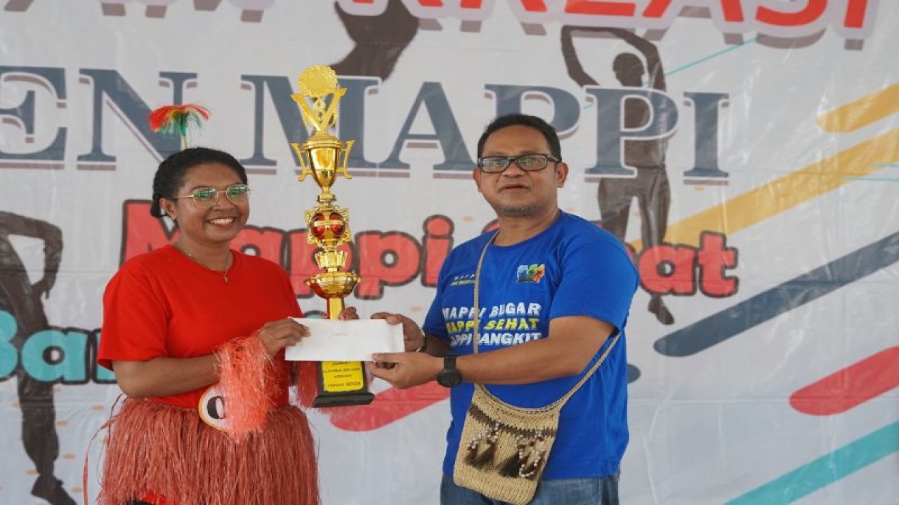 Penjabat Bupati Mappi Michael Gomar saat menyerahkan piala kepada pemenang lomba senam, Sabtu (11/2) (ANTARA/HO-Humas Pemkab Mappi)