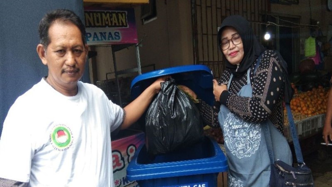 Pedagang Pasar Kesesi, Kabupaten Pekalongan sedang membuang sisa sampah di tempat pembuangan sampah yang disediakan oleh Bank Rakyat Indonesia, di Pekalongan, Kamis (16/2/2023). (ANTARA/Kutnadi)