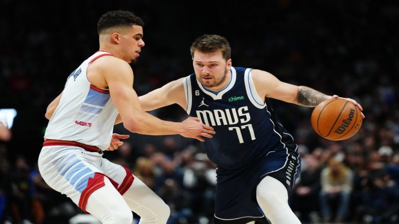 Guard Dallas Mavericks Luka Doncic (kanan) berupaya melewati forward Denver Nuggets Michael Porter Jr. (kiri) saat kuarter ketiga pertandingan NBA kedua tim di Ball Arena. Denver, Colorado, AS, Rabu (15/2/2023) (USA TODAY Sports/Ron Chenoy)