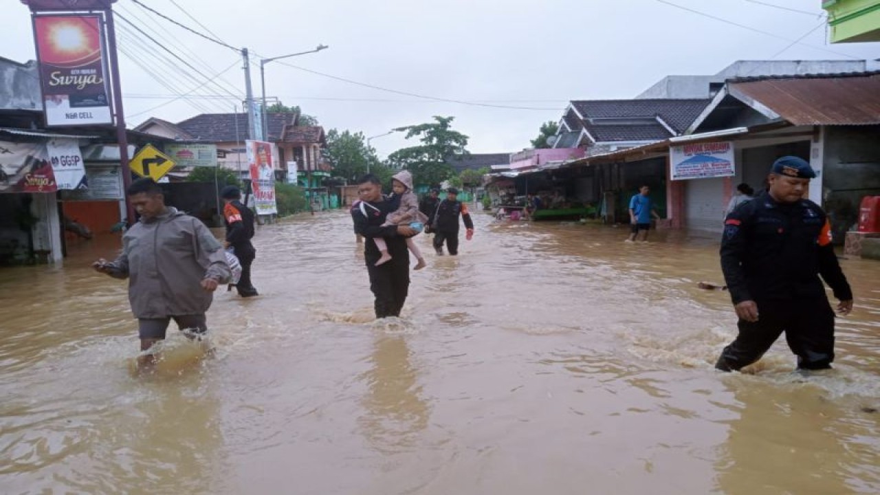 Anggota polisi membantu korban banjir di Sumbawa Barat, Nusa Tenggara Barat, Selasa (14/2/2023) (ANTARA/HO-Humas Polda NTB)